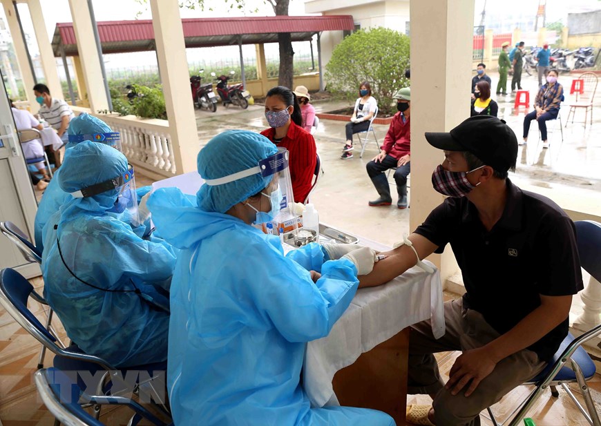 Tổ chức lấy mẫu máu xét nghiệm nhanh Covid-19 cho 250 người dân xã Lê Lợi và hộ kinh doanh trong chợ đầu mối gia cầm Hà Vĩ (huyện Thường Tín), sáng 18-4. (Ảnh: Vũ Sinh-TTXVN)