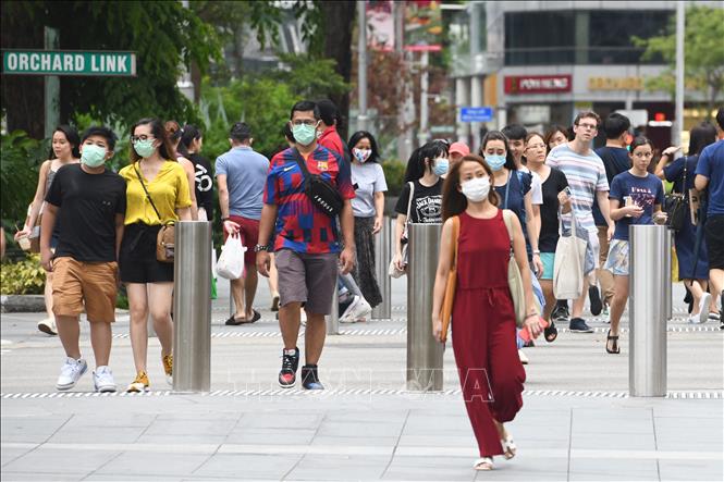 Người dân đeo khẩu trang nhằm ngăn chặn sự lây lan của dịch COVID-19 tại Singapore ngày 5/4. Ảnh: AFP/TTXVN