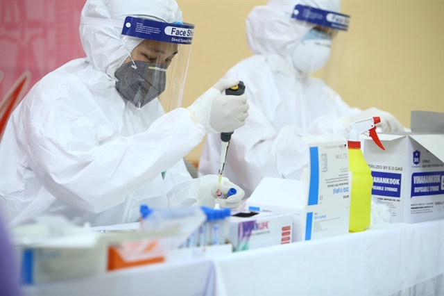 Medical workers test samples taken from citizens in Ha Noi for COVID-19 on Saturday