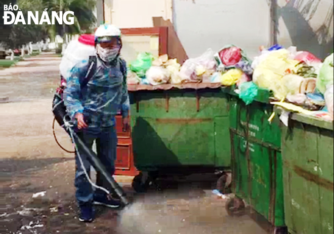 Phun thuốc khử trùng tại các điểm tập kết rác thải trên địa bàn dân cư. (Ảnh chụp tại điểm tập kết rác thải trên đường Nguyễn Tất Thành, quận Thanh Khê). Ảnh: HUỲNH LÊ