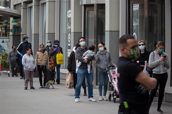 Người dân đeo khẩu trang phòng lây nhiễm Covid-19 khi xếp hàng bên ngoài một cửa hàng ở Brooklyn, New York, Mỹ ngày 14-4-2020. Ảnh: THX- TTXVN