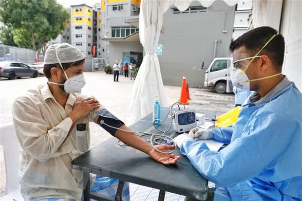 Lao động nước ngoài được kiểm tra y tế tại Singapore ngày 8-4-2020. (Ảnh: THX-TTXVN)