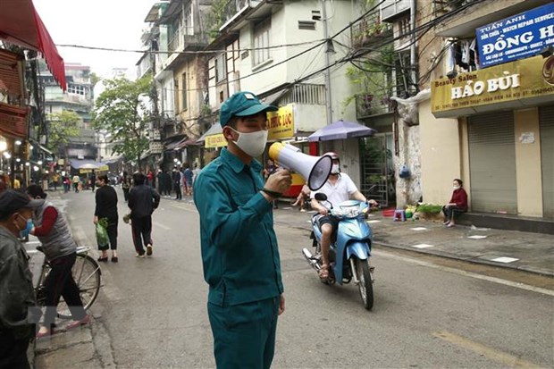 Các lực lượng chức năng làm nhiệm vụ giãn cách xã hội tại phố Nguyễn Thiện Thuật, phường Đồng Xuân, quận Hoàn Kiếm, Hà Nội. (Ảnh: Doãn Tấn-TTXVN)