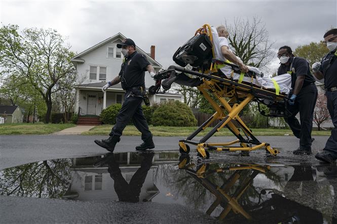 Nhân viên y tế chuyển bệnh nhân mắc COVID-19 tới bệnh viện ở Glen Burnie, Maryland, Mỹ ngày 13/4/2020. Ảnh: AFP/TTXVN