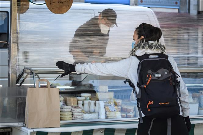 Một cửa hàng bán pho mát được trang bị tấm chắn để ngăn chặn lây lan của dịch COVID-19 tại Geneva, Thụy Sĩ, ngày 16/ 4/2020. Ảnh: AFP/TTXVN