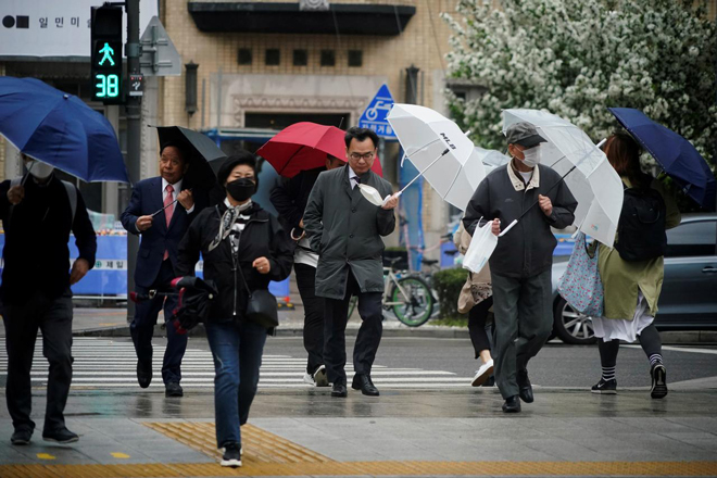 Người dân Hàn Quốc trên đường phố Seoul ngày 20-4. Ảnh: Reuters