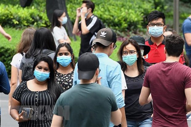 Người dân đeo khẩu trang phòng dịch Covid-19 tại Singapore. (Ảnh: AFP/TTXVN)
