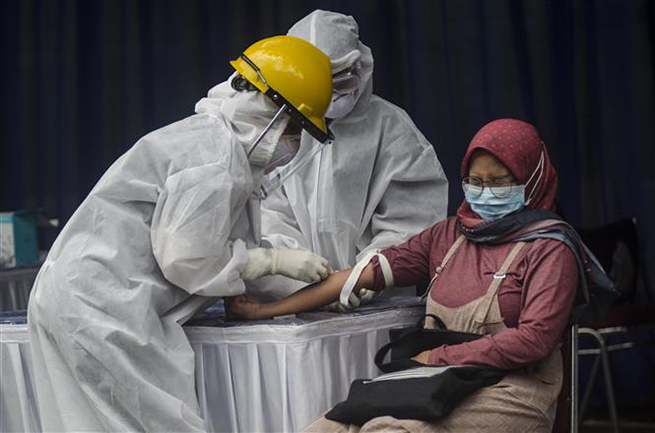  Nhân viên y tế lấy mẫu xét nghiệm Covid-19 cho người dân tại tỉnh Tây Java, Indonesia ngày 4-4-2020. Ảnh: THX/TTXVN