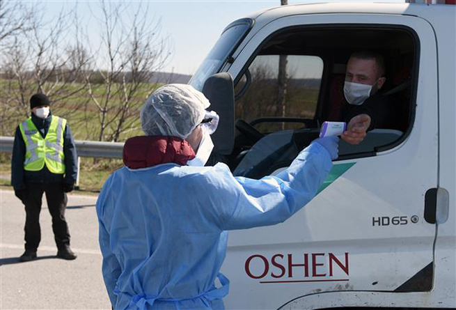   Nhân viên y tế kiểm tra thân nhiệt người dân nhằm ngăn dịch Covid-19 lây lan tại thành phố Lviv, miền Tây Ukraine ngày 10-4-2020. Ảnh: AFP/TTXVN