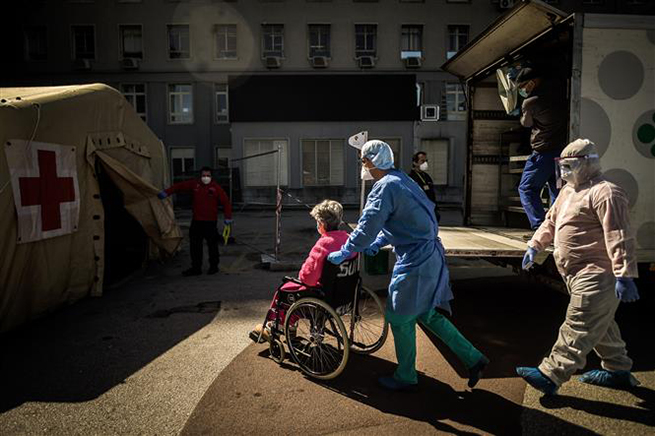   Nhân viên y tế chuyển người nghi nhiễm dịch Covid-19 tới bệnh viện ở Lisbon, Bồ Đào Nha ngày 2-4-2020. Ảnh: AFP/TTXVN