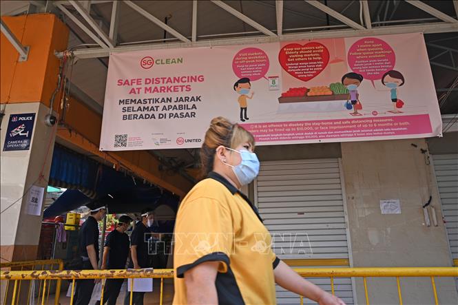 Người dân đeo khẩu trang phòng lây nhiễm dịch COVID-19 tại một chợ ở Singapore, ngày 22/4. Ảnh: AFP/TTXVN