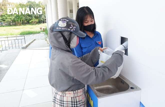 A local resident collecting free rice from a Rice ATM