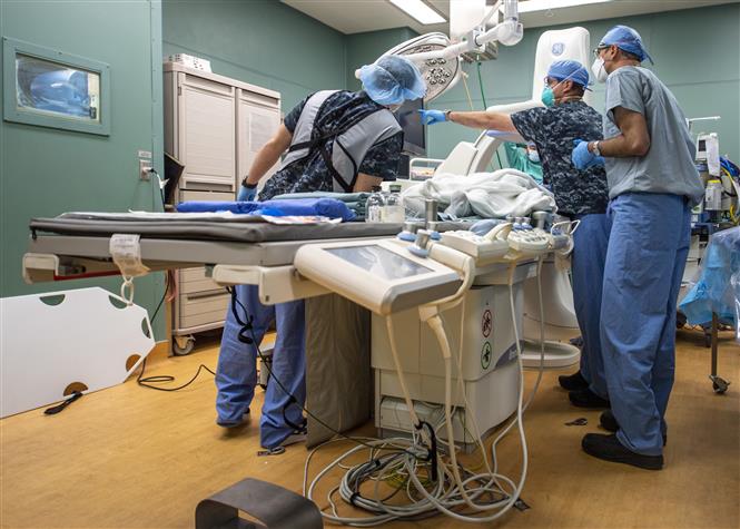 Các bác sĩ kiểm tra kết quả siêu âm của một bệnh nhân nghi nhiễm COVID-19 trên tàu bệnh viện USNS Mercy của hải quân Mỹ ngày 11/4/2020. Ảnh: AFP/TTXVN