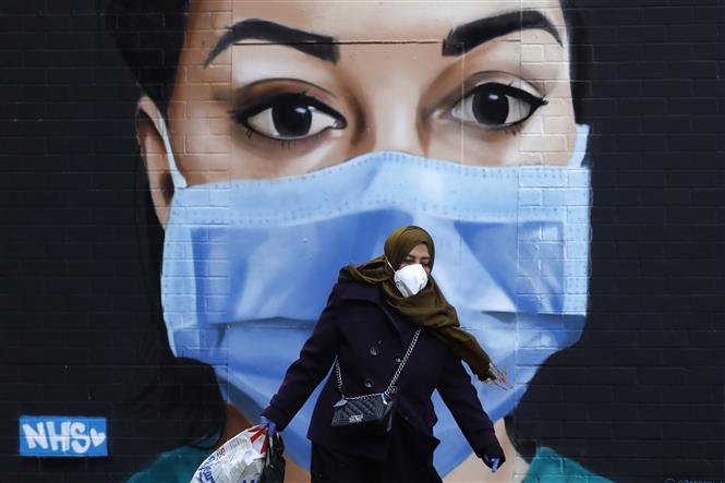 Người dân đeo khẩu trang phòng lây nhiễm COVID-19 tại London, Anh, ngày 22/4/2020. Ảnh: AFP/TTXVN