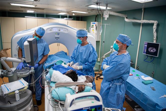 Nhân viên y tế điều trị cho bệnh nhân mắc COVID-19 trên tàu bệnh viện USNS Mercy ở Los Angeles, Mỹ ngày 18/4/2020. Ảnh: AFP/TTXVN