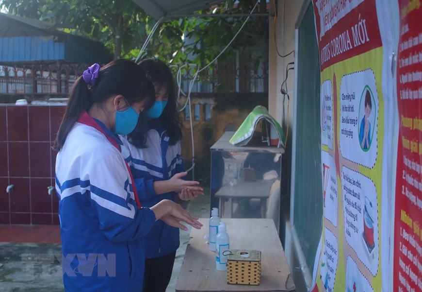 Học sinh Cao Bằng rửa tay bằng nước sát khuẩn trước khi vào lớp. (Ảnh: Chu Hiệu/TTXVN)
