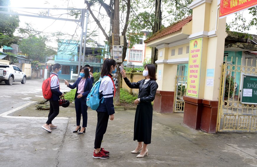  Học sinh trường THCS Phát Thiết, thành phố Tuyên Quang được kiểm tra thân nhiệt trước khi vào trường. (Ảnh: Quang Cường/TTXVN)