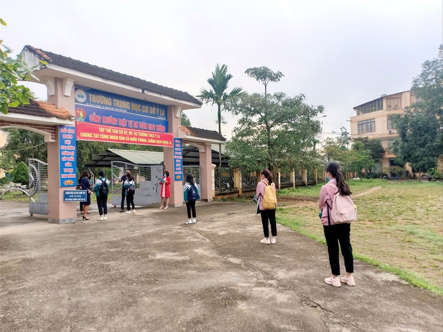Học sinh trường THCS Ỷ La, thành phố Tuyên Quang được kiểm tra thân nhiệt trước khi vào trường. (Ảnh: Quang Cường/TTXVN)