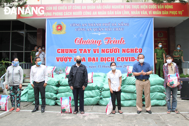 Công an quận Hải Châu trao hỗ trợ gạo cho hộ nghèo gặp khó khăn do Covid-19.  Ảnh: QUỐC BẢO