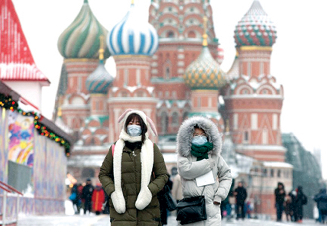 Người dân mang khẩu trang khi đi lại trên đường phố ở Moscow.  Ảnh: Bloomberg