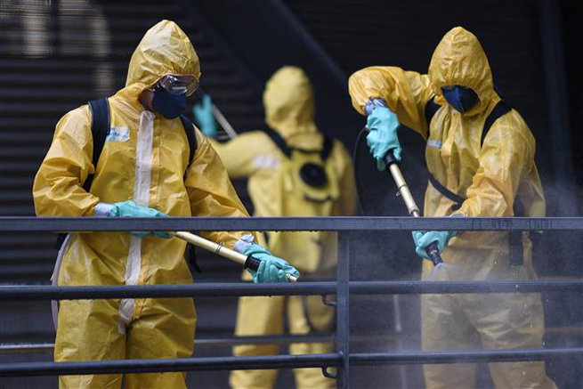 Phun thuốc khử trùng nhằm ngăn chặn sự lây lan của Covid-19 tại trạm xe buýt ở Belo Horizonte, Brazil, ngày 9-4-2020. Ảnh: AFP/ TTXVN