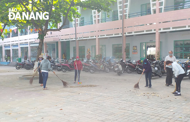 Teachers from the Nguyen Van Troi Primary School cleaning up the environment at the schoolyard