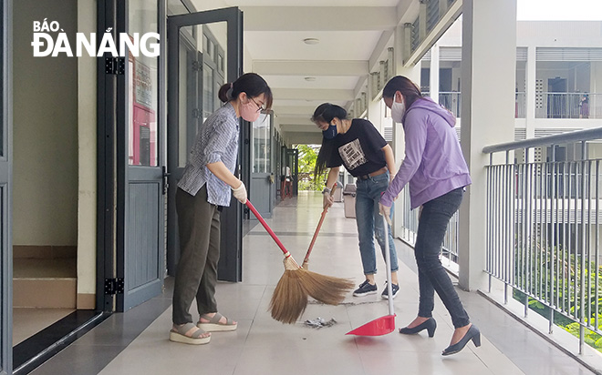 Teachers of the Phan Chau Trinh Senior High School sweeping the floor