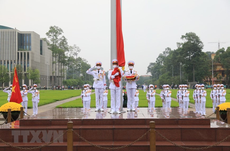 3 chiến sĩ hồng kỳ nghiêm trang bước lên bục chuẩn bị thực hiện nghi thức thượng cờ. (Ảnh: Thành Đạt-TTXVN)