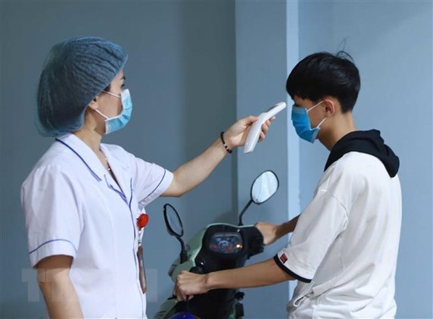 Checking body temprature at a Vietnamese hospital (Photo: VNA)