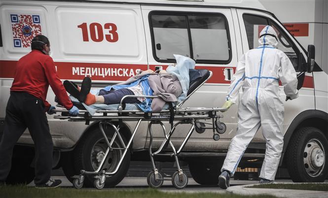  Nhân viên y tế chuyển bệnh nhân nhiễm COVID-19 tới bệnh viện ở Moskva, Nga, ngày 27/4/2020. Ảnh: AFP/TTXVN