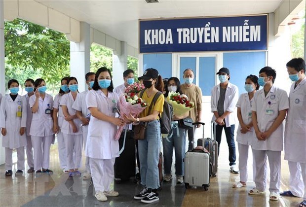 Leading officials of a hospital in Ninh Binh presents flowers to recovered Covid-19 patients (Source: VNA)