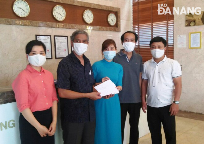 Leader of the Hai Chai District (2nd left) handing quarantine completion certificates to three Italian nationals through the Da Nang Petrol Hotel's representatives 