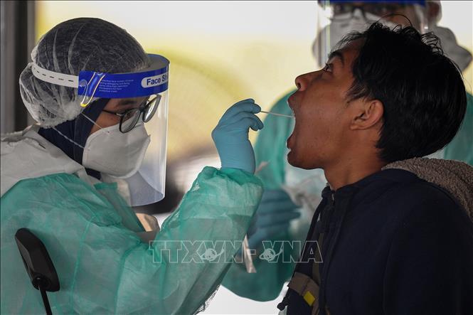 Nhân viên y tế xét nghiệm cho người dân tại Malaysia. Ảnh: AFP/TTXVN
