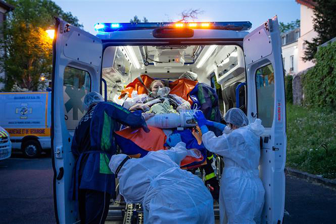 Nhân viên y tế chuyển bệnh nhân Covid-19 lên xe cứu thương tại Epinay sur Seine, gần Paris, Pháp ngày 22-4-2020. Ảnh: THX/ TTXVN