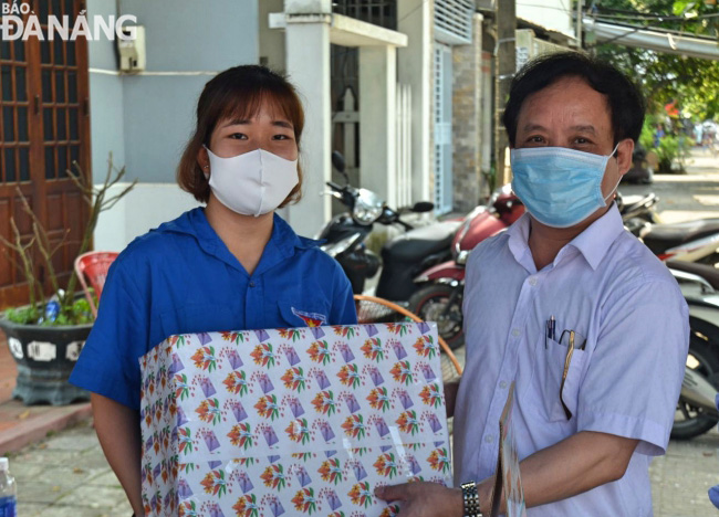 Assoc. Prof. PhD. Nguyen Ngoc Vu, Director of the University of Da Nang (right) presenting a gift to student volunteers who are staffing 7 checkpoints across the city. 