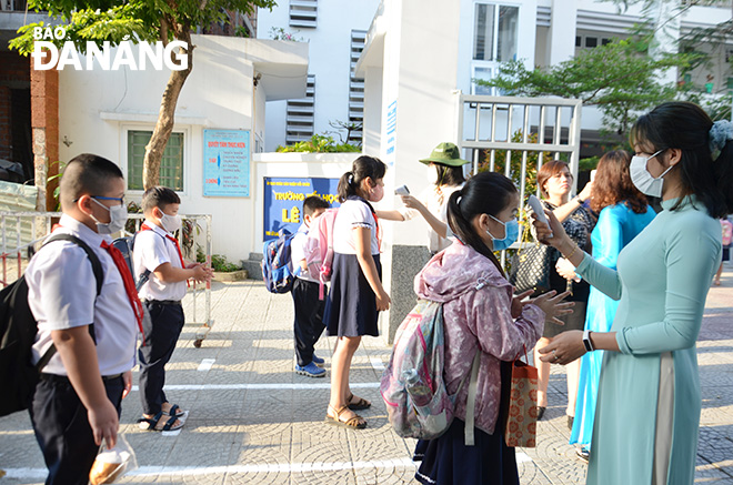 White markings on the ground at the Hai Chau District-based Le Lai Primary School ensure that pupils are able to maintain a safe distance of 1m from each other while having temperatures checked.