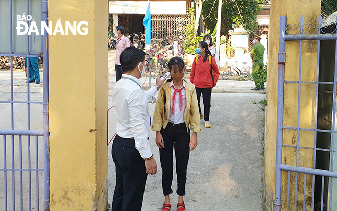 Teachers and healthcare workers screening pupils’ temperatures at the Nguyen Tri Phuong Junior High School in Hoa Vang District’s Hoa Bac Commune.