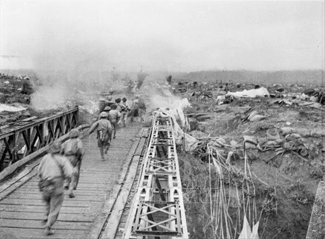 Bộ đội ta vượt qua cầu Mường Thanh, tấn công vào Sở chỉ huy Tập đoàn cứ điểm Điện Biên Phủ, chiều 7/5/1954. Ảnh: Tư liệu TTXVN.