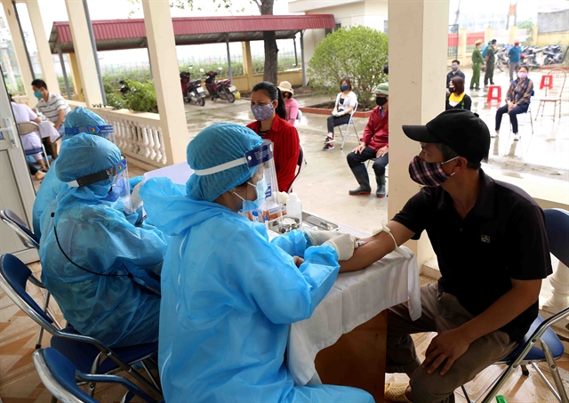 Medical workers conduct rapid COVID-19 tests for people in Lê Lợi Commune and vendors at Hà Vỹ Poultry Wholesale Market in Hà Nội's Thường Tín District last month