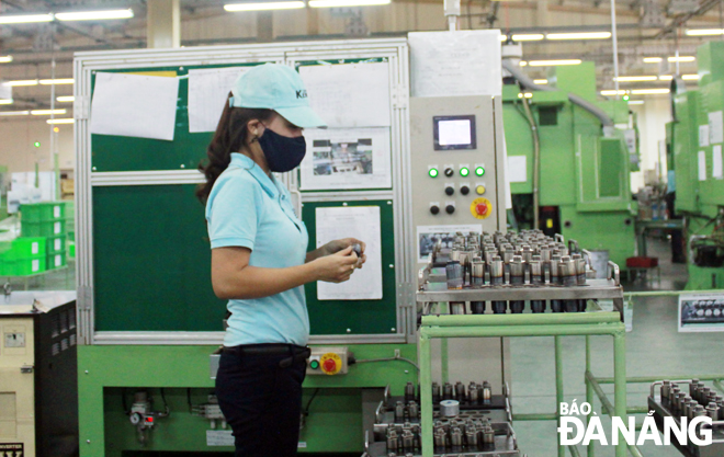 An employee from the Tokyo Keiki Precision Technology Inc wearing a face mask during her working shift