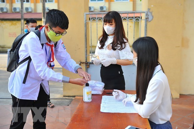 Students disinfect their hands with sanitizer (Source: VNA)