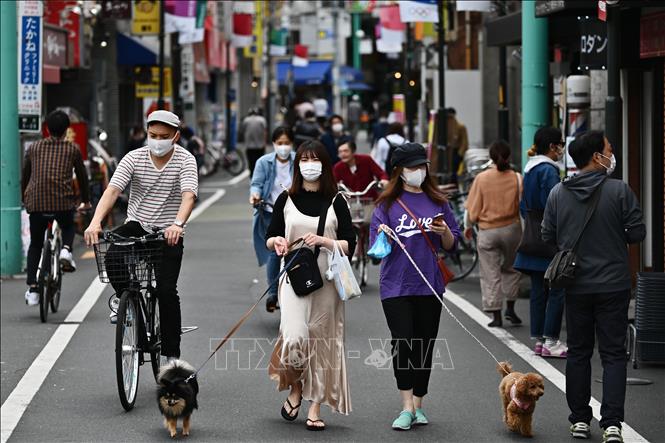 Người dân đeo khẩu trang khi đi mua sắm tại một tuyến phố ở Tokyo, Nhật Bản ngày 4/5/2020. Ảnh: AFP/TTXVN