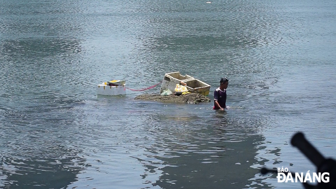 Một người dân trầm mình mưu sinh trên sông Hàn trong ngày nắng nóng.