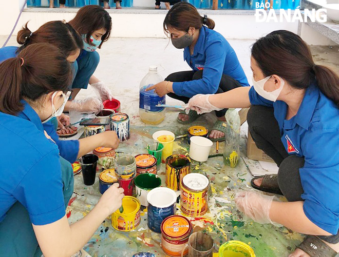 Đoàn Thanh niên Trường mầm non Bình Minh pha màu để trang trí lại trường, lớp sau hơn 3 tháng các em học sinh nghỉ học. Ảnh: NGỌC PHÚ