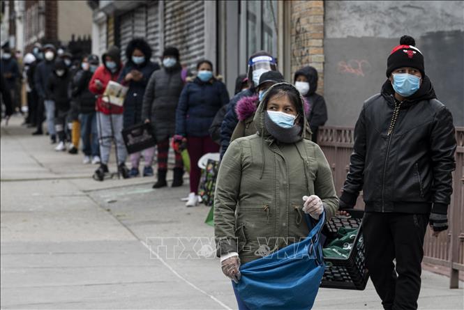 Người dân đeo khẩu trang phòng dịch COVID-19 xếp hàng chờ nhận thực phẩm tại một điểm phân phát ở New York, Mỹ ngày 29/4/2020. Ảnh: AFP/TTXVN