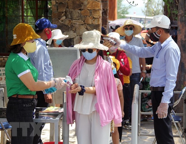 Khách du lịch rửa tay sát khuẩn khi vào tham quan một điểm du lịch ở tỉnh Phú Yên. (Ảnh: Xuân Triệu/TTXVN)