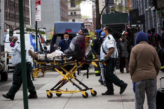  Lực lượng phản ứng nhanh chuyển một người nghi nhiễm Covid lên xe cứu thương ở khu Brooklyn, New York, Mỹ ngày 8-5-2020. Ảnh: THX/TTXVN