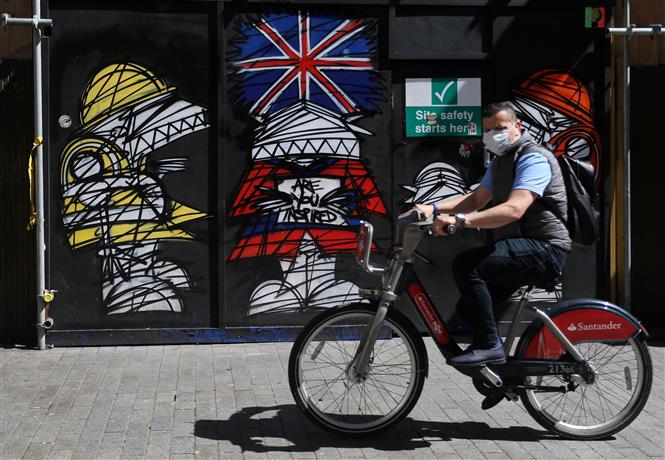  Người dân đi làm bằng xe đạp tại London, Anh, ngày 21-4-2020. Ảnh: AFP/TTXVN