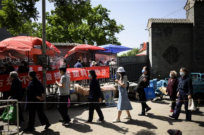  Người dân xếp hàng thực hiện biện pháp giãn cách xã hội khi vào chợ tại Bắc Kinh, Trung Quốc, ngày 10/5/2020. Ảnh: AFP/TTXVN