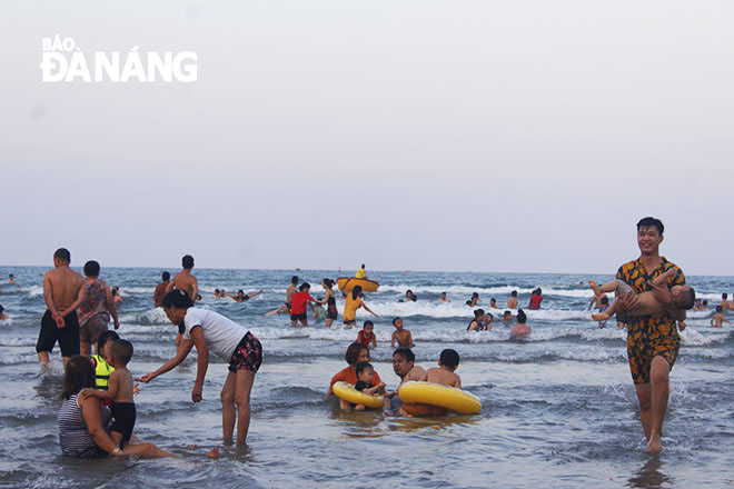 Children are seen to swim in areas supervised by their parents and lifeguards.